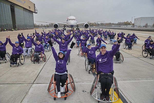 aircraft being pulled by wheelchair team