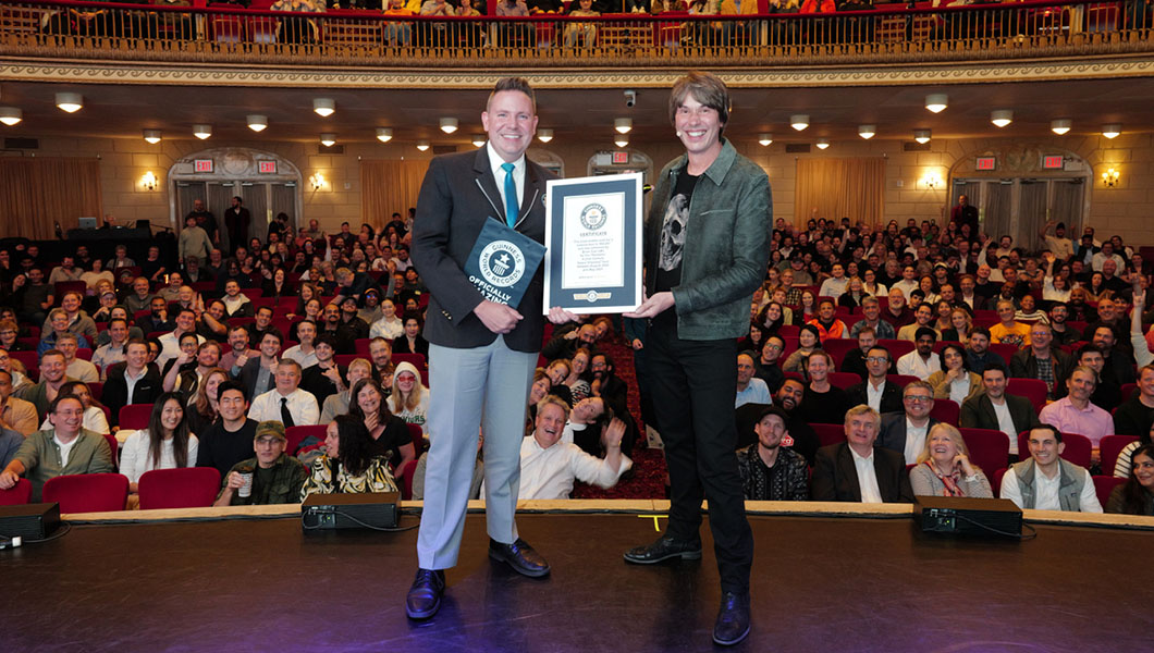 Professor Brian Cox smiling on stage with certificate