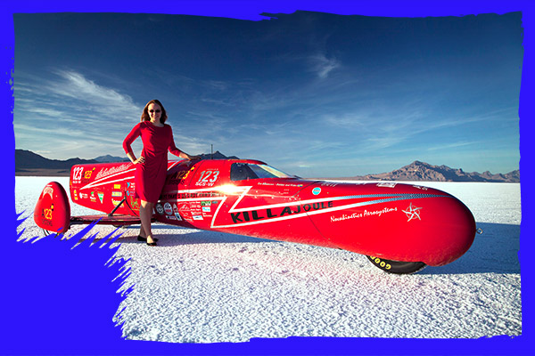 woman in red next to fastest 3 wheeled bike