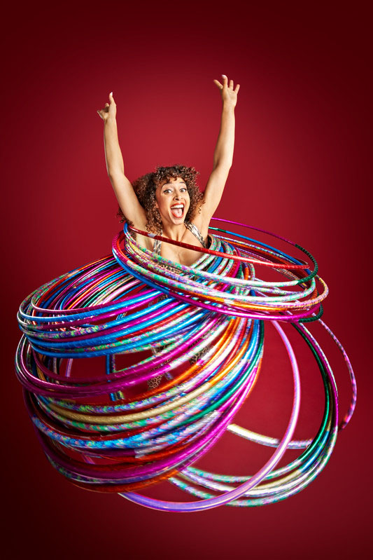 marawa spinning multiple hula hoops in red background