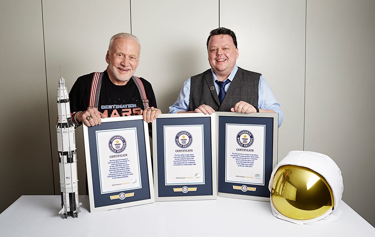 Buzz Aldrin holding his three GWR certificates and GWR Editor-in-Chief Craig Glenday in 2016