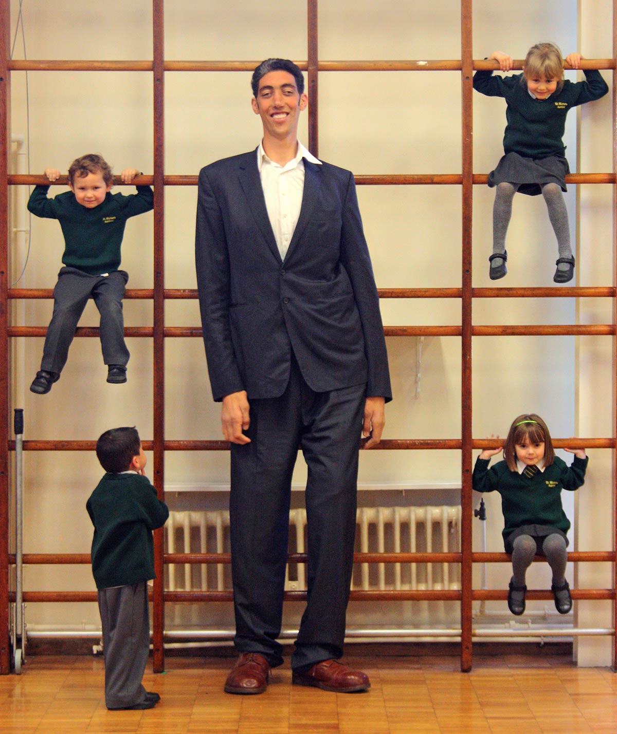 Sultan standing next to kids playing on apparatus 