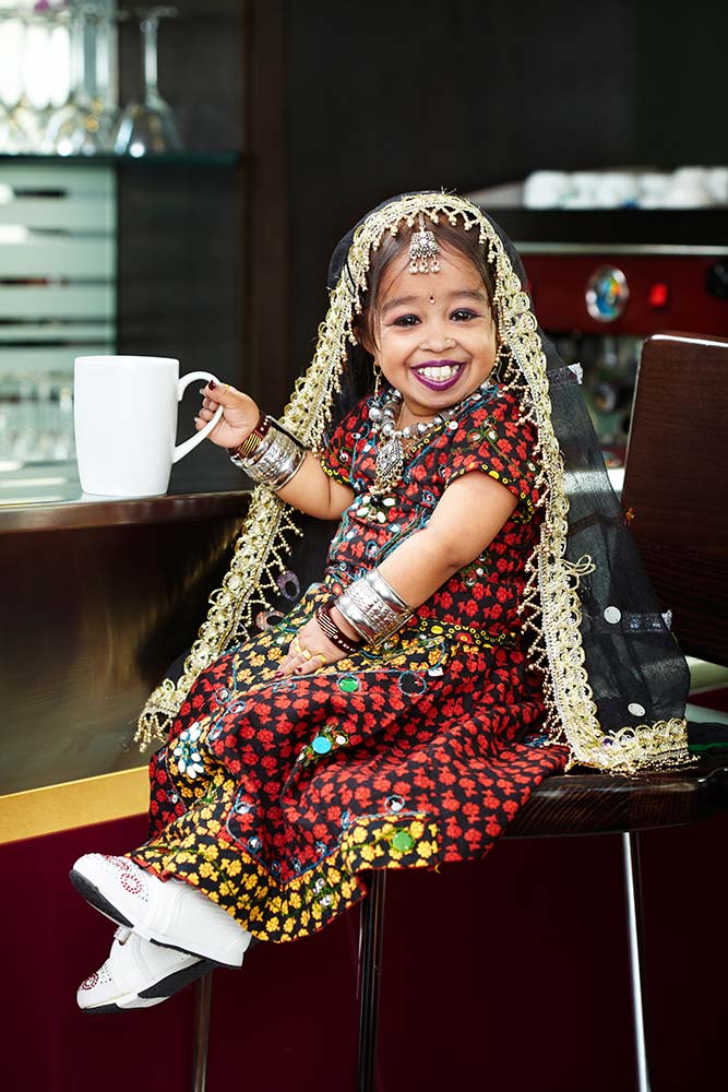 Jyoti sitting down on a chair holding a mug