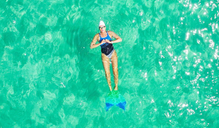 Merle Liivand swimming in ocean with a monofin