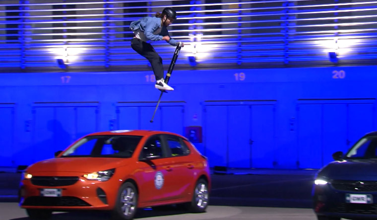 man jumping over cars with pogo stick
