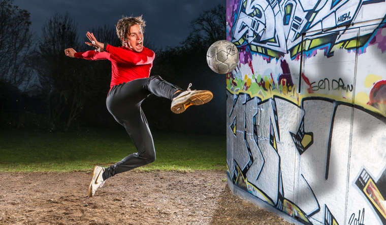 John Farnworth volleying football against wall
